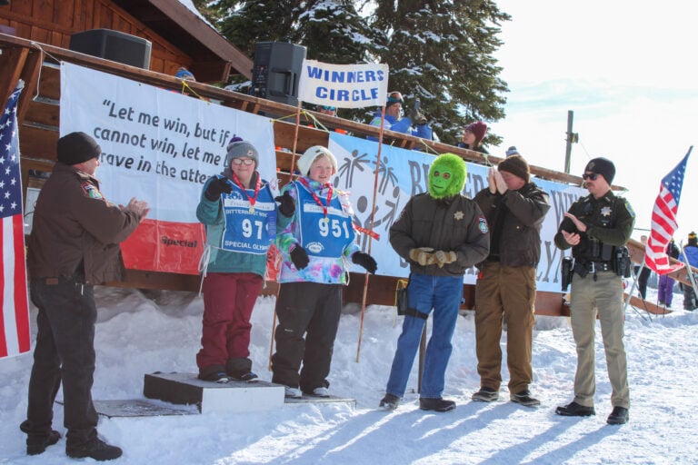 A group of people participating in the Winter Special Olympics, standing in the snow.