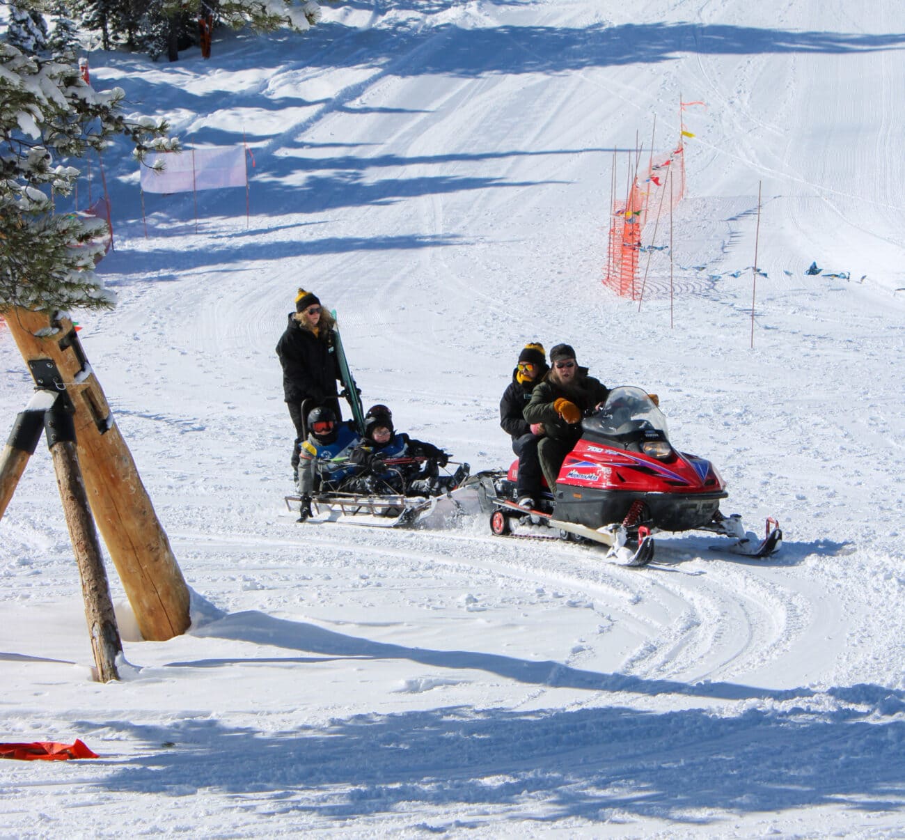 A group of people participating in the Bitterroot Winter Special Olympics on a snowmobile.