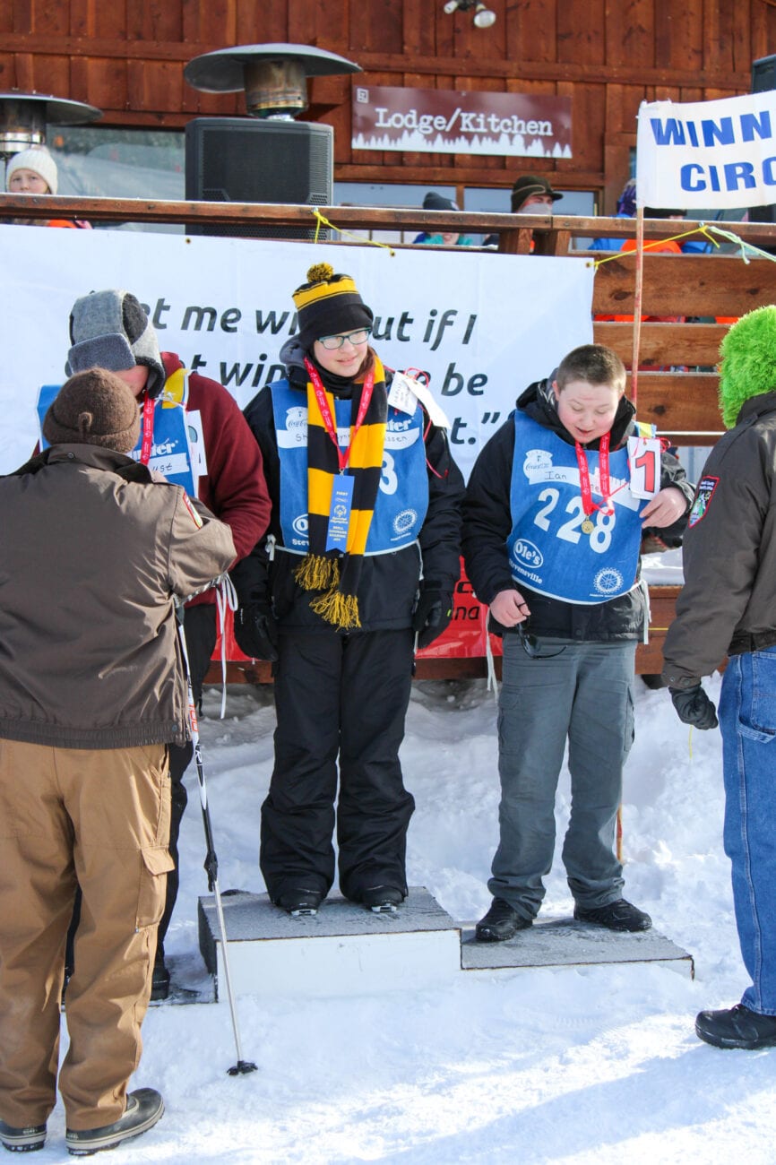 A group of people participating in the Winter Special Olympics, standing in the bitterroot snow.