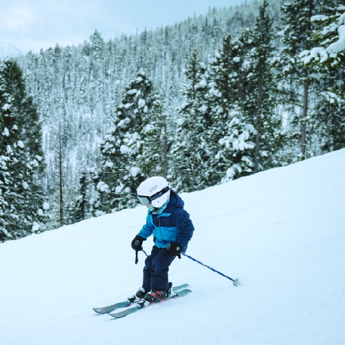 A young boy skiing down a snowy slope at Lost Trail Ski Area.