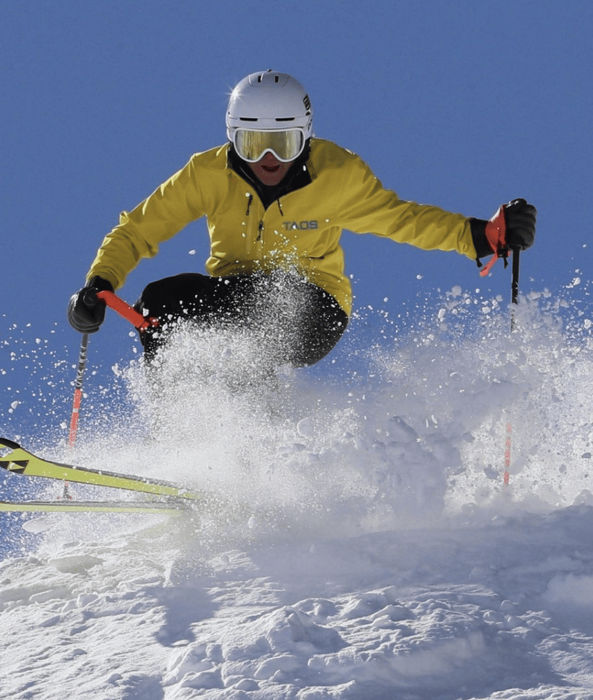 Deb Armstrong, a person in a yellow jacket, skiing down a snowy slope at Lost Trail.